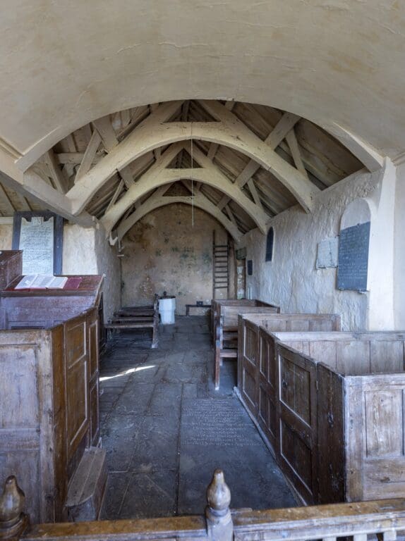 An old church interior with wooden roof and seats